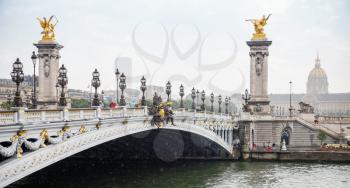 Paris, France - August 07, 2014: People walking on the Pont Alexandre III (Alexander III bridge) in a rainy summer day