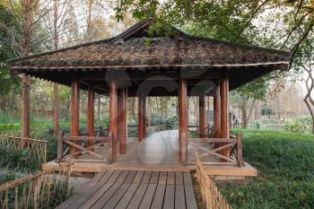 Wooden pathway and traditional Chinese Gazebo. Walking around famous West Lake park in Hangzhou city center, China