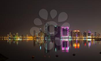 Night modern city skyline with shining lights and reflections in water. Manama, the Capital of Bahrain Kingdom, Middle East
