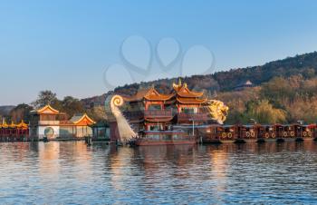 Hangzhou, China - December 5, 2014: Chinese wooden recreation boats and Dragon ship are moored on the West Lake. Famous park in Hangzhou city center, China