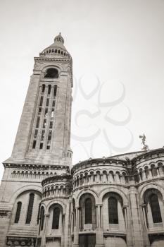 Belltower of Sacre Coeur Basilica, large medieval cathedral, Basilica of Sacred Heart, popular landmark of Paris, France. Sepia toned photo