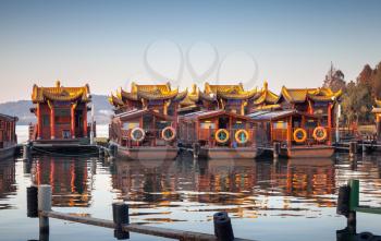 Traditional Chinese wooden recreation boats are moored on the West Lake coast. Famous park in Hangzhou city center, China