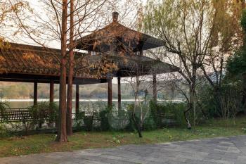 Wooden traditional Chinese gazebo on the coast. Walking around famous West Lake park in Hangzhou city, China