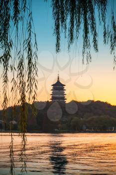 Chinese pagoda on the coast of West Lake. Famous park in Hangzhou city center, China. Colorful tonal photo filter