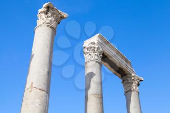 Ancient columns and portico fragment on blue sky background, fragment of ruined roman temple in Smyrna. Izmir, Turkey