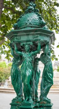 Outdoor fountain with women group sculpture near Saint-Sulpice church on Rue Bonaparte, Paris, France
