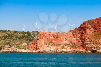 Kaliakra headland. Bulgaria, Black Sea. Coastal landscape with red cliff and wind turbines
