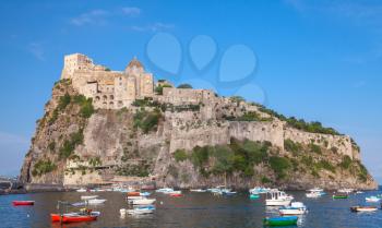 Coastal landscape of Ischia port with Aragonese Castle and colorful wooden boats