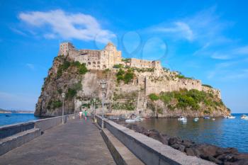 Coastal landscape of Ischia port with Aragonese Castle and empty road on the dam