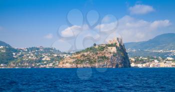 Coastal landscape of Ischia with Aragonese Castle on rocky island. Mediterranean sea coast, Italy