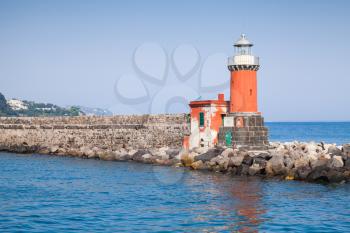 Red lighthouse tower, entrance of Ischia Porto. Mediterranean sea, Italy
