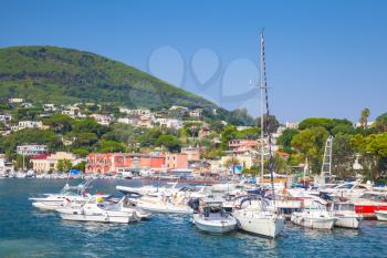 Yachts and pleasure motor boats moored in port of Ischia island. Mediterranean sea, Italy