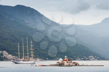 Bay of Kotor. Small island Our Lady of the Rocks and big sailing ship