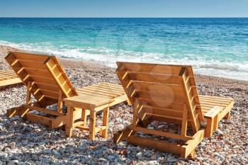 Two wooden sun loungers stand on the Adriatic Sea coast in Montenegro