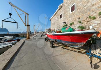 Red fishing boat stands on the coast in port of Petrovac, Montenegro