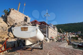 White fishing boat stands on the coast in port of Petrovac, Montenegro