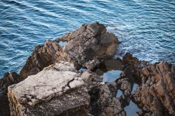 Dark coastal rocks on Adriatic Sea in Montenegro