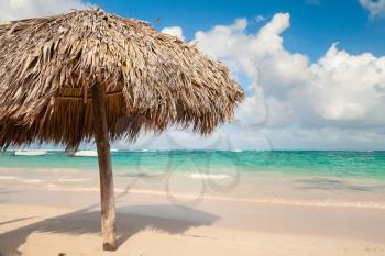Wooden umbrella on empty sandy beach in Dominican republic 