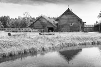 Russian rural wooden architecture example, old houses on the lake coast, black and white photo