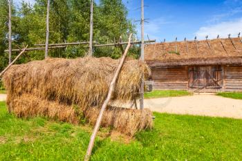 Russian wooden rural architecture example, outdoor hay drying construction near old barn with locked gate
