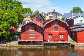 Old red wooden houses on the river coast in historical Finnish town Porvoo
