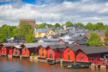 Old red wooden houses on river coast. Porvoo, small historical town in Finland