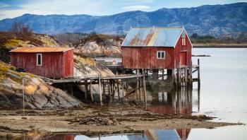 Coastal Norwegian red wooden barn and houses with piles