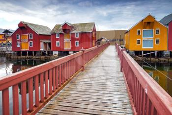 Wooden bridge and colorful houses in coastal Norwegian fishing village. Rorvik, Norway
