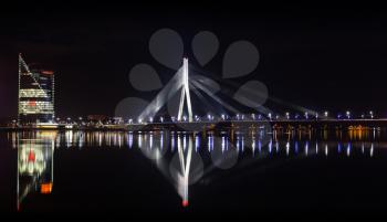RIGA, LATVIA - DECEMBER 30, 2013: Night panorama of Daugava River with illuminated modern Vansu cable-stayed bridge
