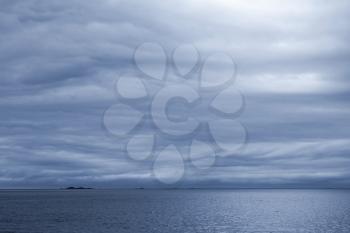 Dark blue stormy cloudy sky. Empty Norwegian Sea landscape background