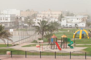 Dust storm. Playground with palms, Saudi Arabia