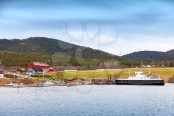 Traditional Norwegian small village with colorful wooden houses and ferry