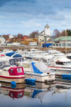 Typically Norwegian fishing village landscape. Small boats are moored in marina