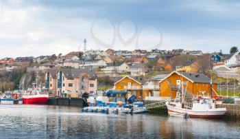 Small Norwegian fishing village, wooden houses and moored boats on the North sea coast 