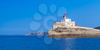 Madonetta, lighthouse tower with red top on coastal rock. Entrance to Bonifacio port. Mountainous Mediterranean island Corsica, Corse-du-Sud, France
