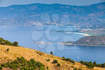 Summer coastal landscape of French mountainous island Corsica. Small trees grow on coastal hills. Piana region, France