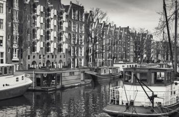 Living houses and houseboats along the canal in Amsterdam, Netherlands. Retro stylized sepia toned monochrome photo