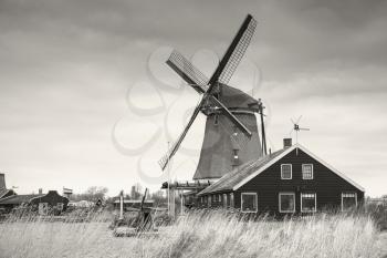 Windmill in Zaanse Schans town. It is one of the popular tourist attractions of the Netherlands. Retro stylized sepia toned monochrome photo