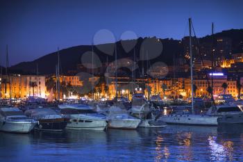 Pleasure yachts and motor boats moored in old port of Ajaccio, Corsica island, France. Dark night photo