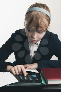 School girl using calculator, closeup portrait over white wall background
