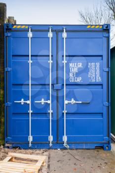 Closed blue standard shipping cargo container, gate side