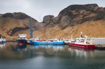 Fishing boats and cargo ships moored in port of Vestmannaeyjar island, Iceland