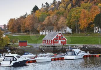 Norwegian village on the sea coast. Wooden houses and moored boats. Hasselvika, village in the municipality of Rissa in Sor-Trondelag county, Norway