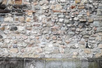 Old grungy gray stone wall, close-up flat background photo texture
