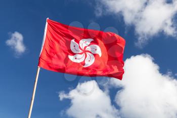 Hong Kong flag waving over blue cloudy sky background