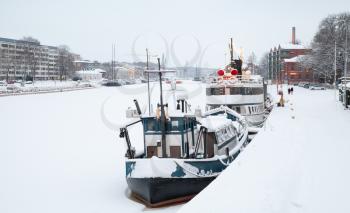 Small boats are moored near river coast in Turku town, Finland