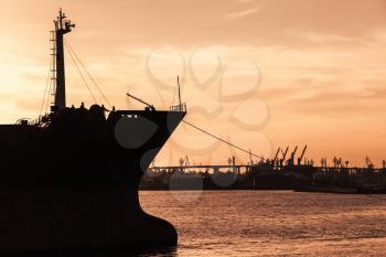 Industrial cargo ship bow silhouette in sunset, Varna harbor, Bulgaria