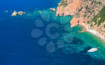 Luxury white pleasure yacht anchored near rocky coast of Corsica island, birds eye view 