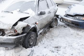 Two crashed cars in accident on winter road with snow