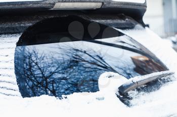 Car wiper on rear window with snow in cold winter season